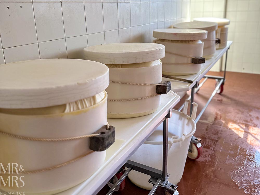 Parmesan press shaping the cheese. Tour of parmegiano reggiano parmesan cheese and prosciutto di Parma in Parma Italy
