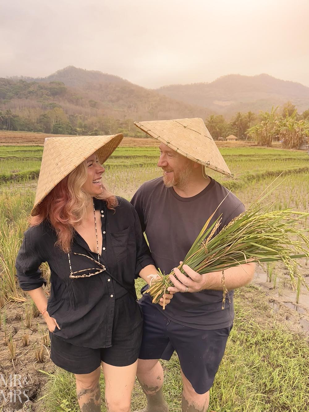 Living Land Farm Company, Luang Prabang, Laos - Jim and Christina in a rice paddy with harvested rice