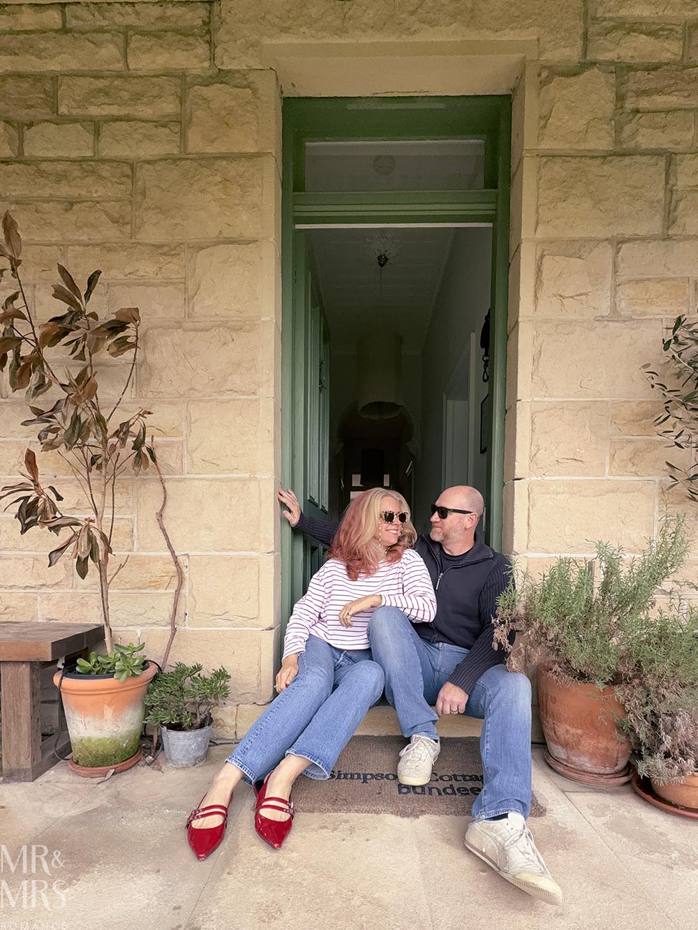 Simpson Cottage Review - Jim and Christina sitting in the doorway of the sandstone cottage