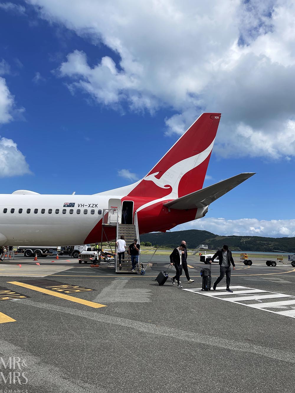 Is travel insurance worth it? Boarding a plane. Qantas tail fin